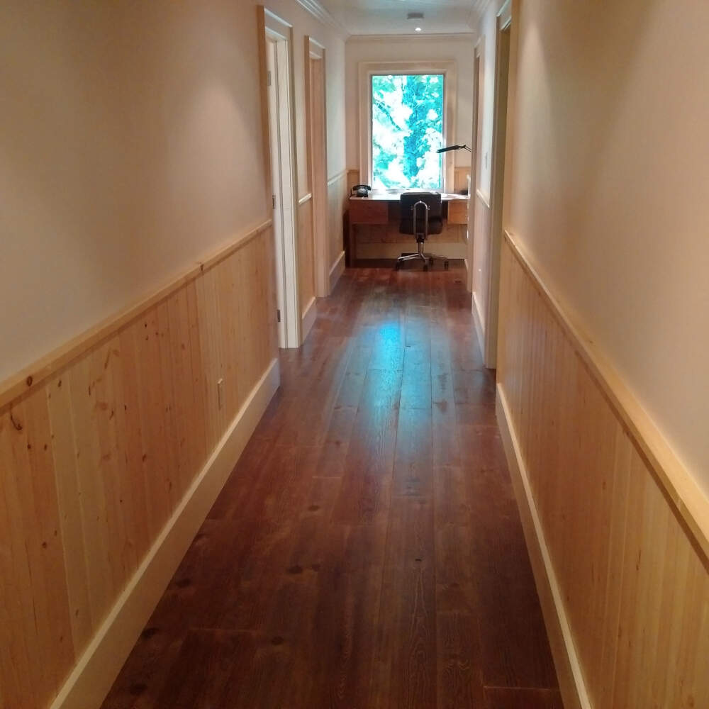 A combination of wood panel wainscoting and gypsum wallboard upper wall finishes lend a formal feel to this cottage interior in Muskoka.