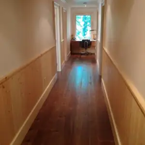 Natural light illuminates a writing desk positioned at the North-East end of the corridor.