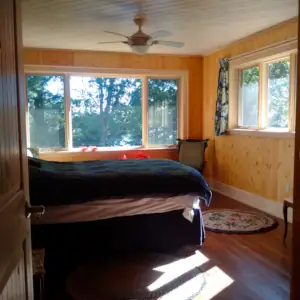 The Master Bedroom overlooks the lake through a picture window supplemented by operable casement windows for cross-ventilation.