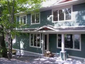 A three season porch provides a quiet sanctuary away from common spaces in the main cottage floor plan.