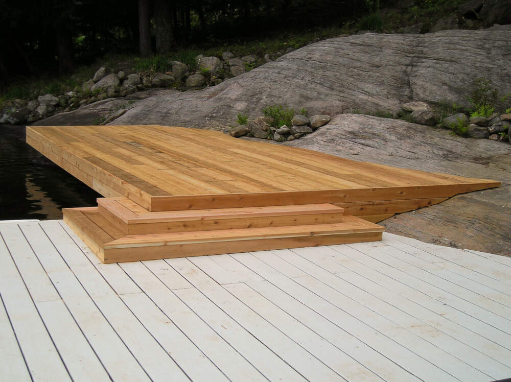 Cedar swim dock that hugs the curves of a bedrock outcropping on a property near the mouth of the Joseph River at Lake Rosseau in Muskoka, Ontario.