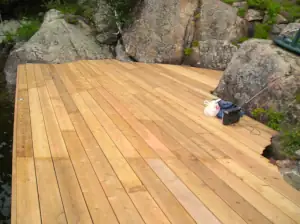 New cedar decking is cut to conform to the curves of the surrounding granite rock outcrop.