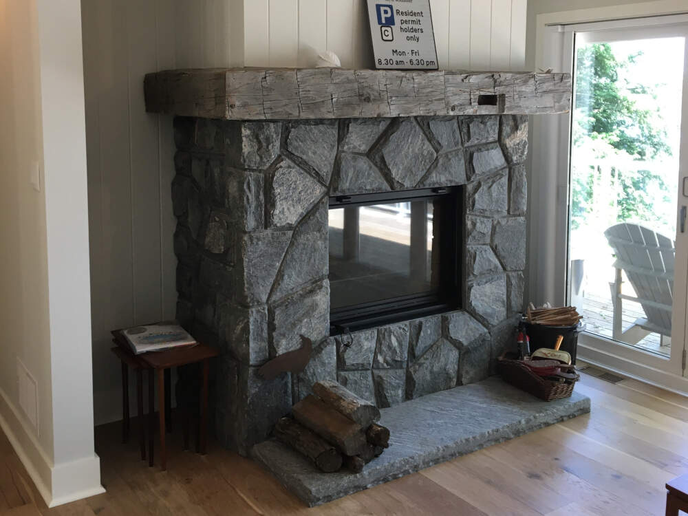 A wood-burning masonry fireplace with timber mantel is the centrepiece of the Living Room in this cottage.