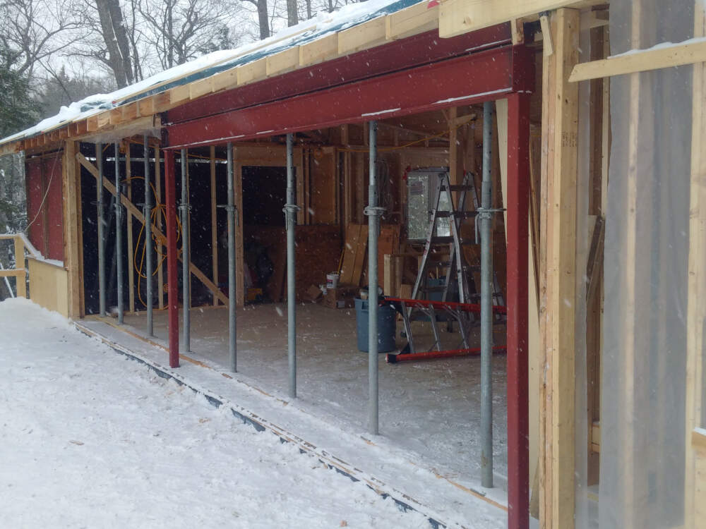 Steel shoring posts temporarily support a wood-frame roof structure while steel columns and beams are hoisted into place, assembled and welded on-site by a CWB-Certified welding contractor.