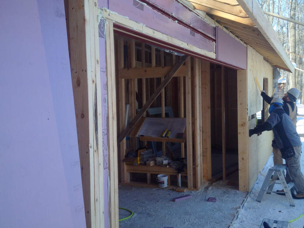 Carpenters install exturded polystyrene insulation to provide a thermal break between unconditioned outdoor temperatures and steel structural components to eliminate thermal bridging.