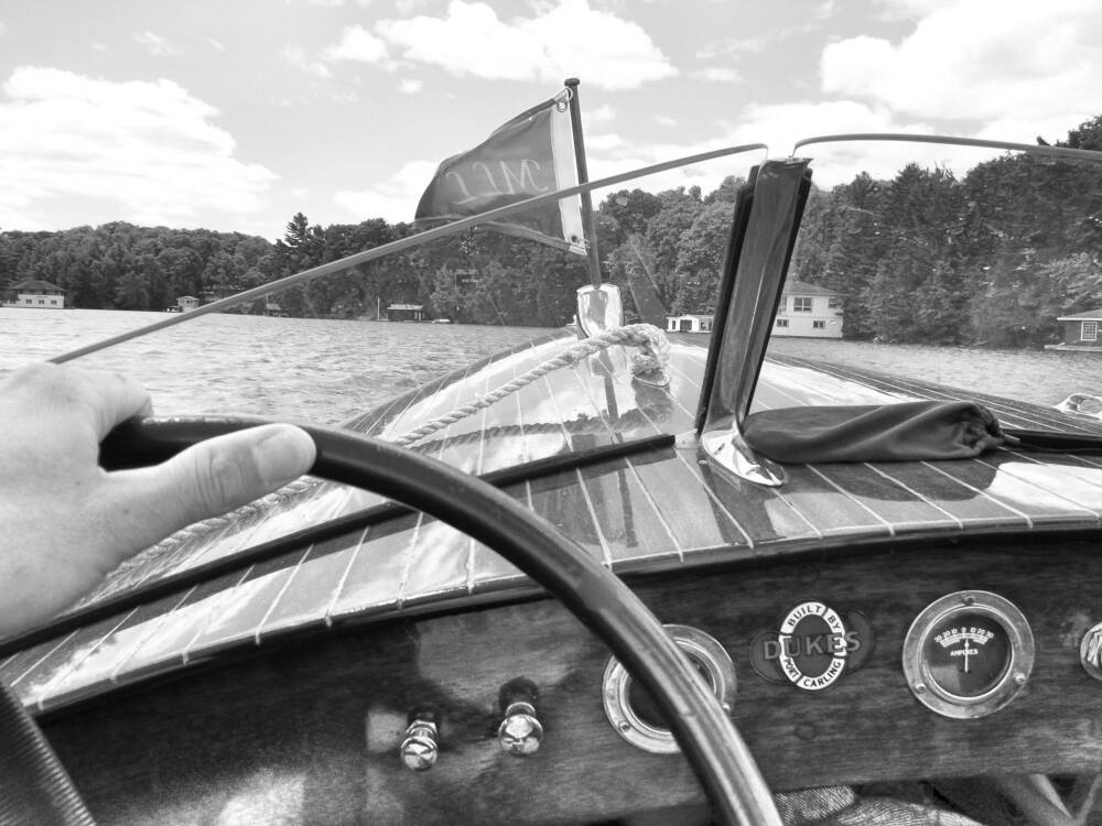 First-person view of driving a classic wooden boat on Lake Joseph in Muskoka, Ontario cottage country.