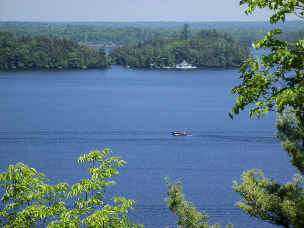 A wooden boat is pictured in a large area of open water to represent the transportation and logistical challenges presented by water-access-only construction sites.
